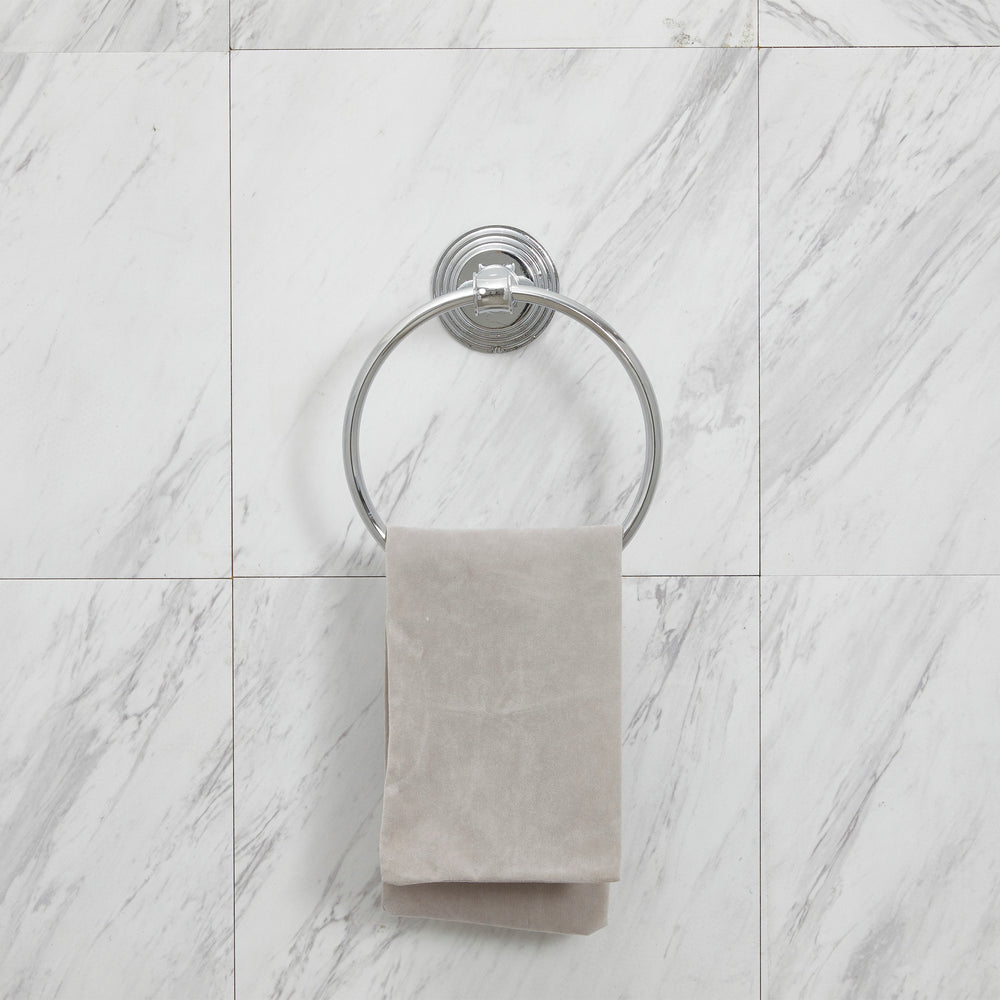 Teamson Home Wall Mounted Towel Ring, Chrome, hanging on a marble wall.
