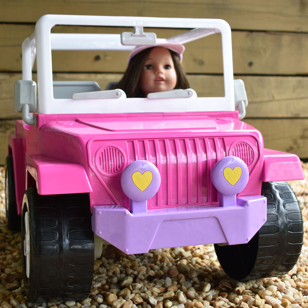 A brunette 18" doll sitting in a hot pink cruiser on gravel.