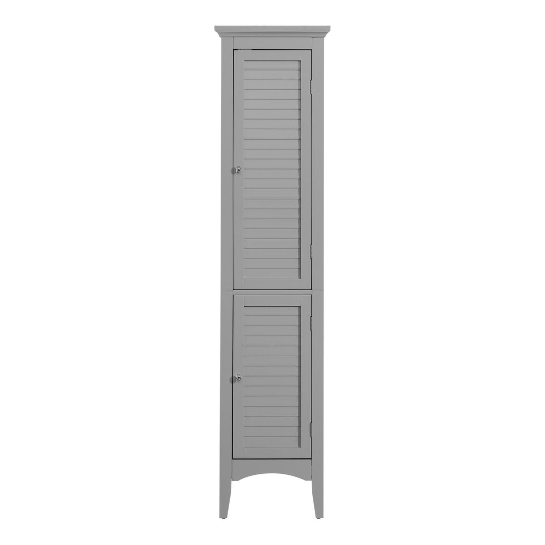 A Teamson Home Glancy Wooden Linen Tower Cabinet with Storage, Gray with shutters on the door.