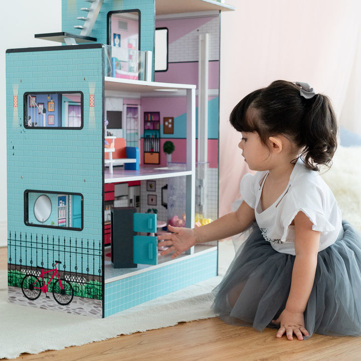 A little girl opening the refrigerator on the first floor of the dollhouse.