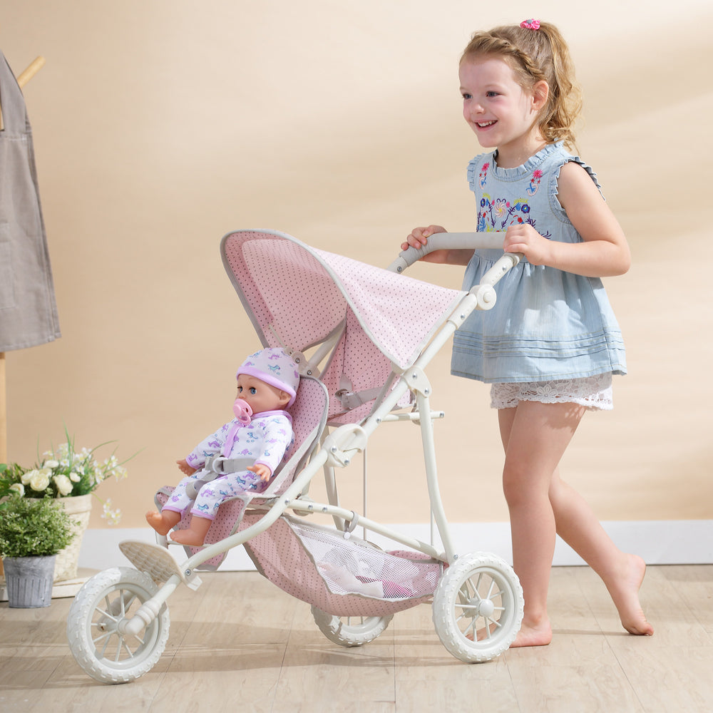 A little girl in blue and white pushing the tandem jogging stroller, pink with gray polka dots, with a baby doll sitting in the front seat.