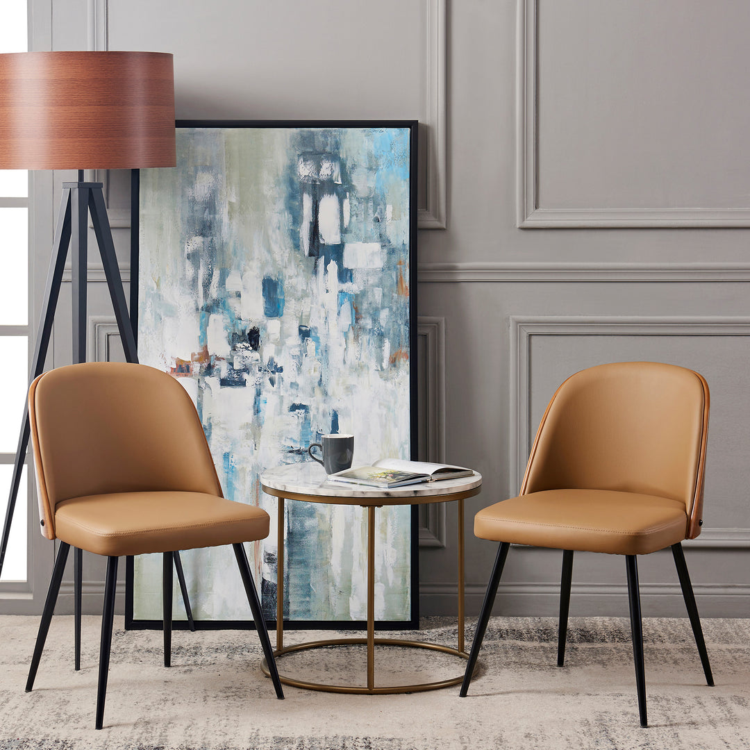 Two Teamson Home Layton dining chairs with black metal legs and cherry wood seatback, khaki and a coffee table in front of a painting.