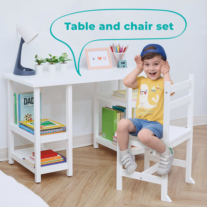 A picture of a little boy with a blue cap, yellow tee, and blue shorts on sitting at a children's white desk on a matching chair with the label "Table and Chair Set".