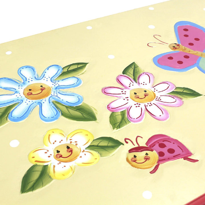 A yellow Fantasy Fields Kids Magic Garden Kids Wooden Toy Storage Chest with butterflies, flowers, and a ladybug on it.