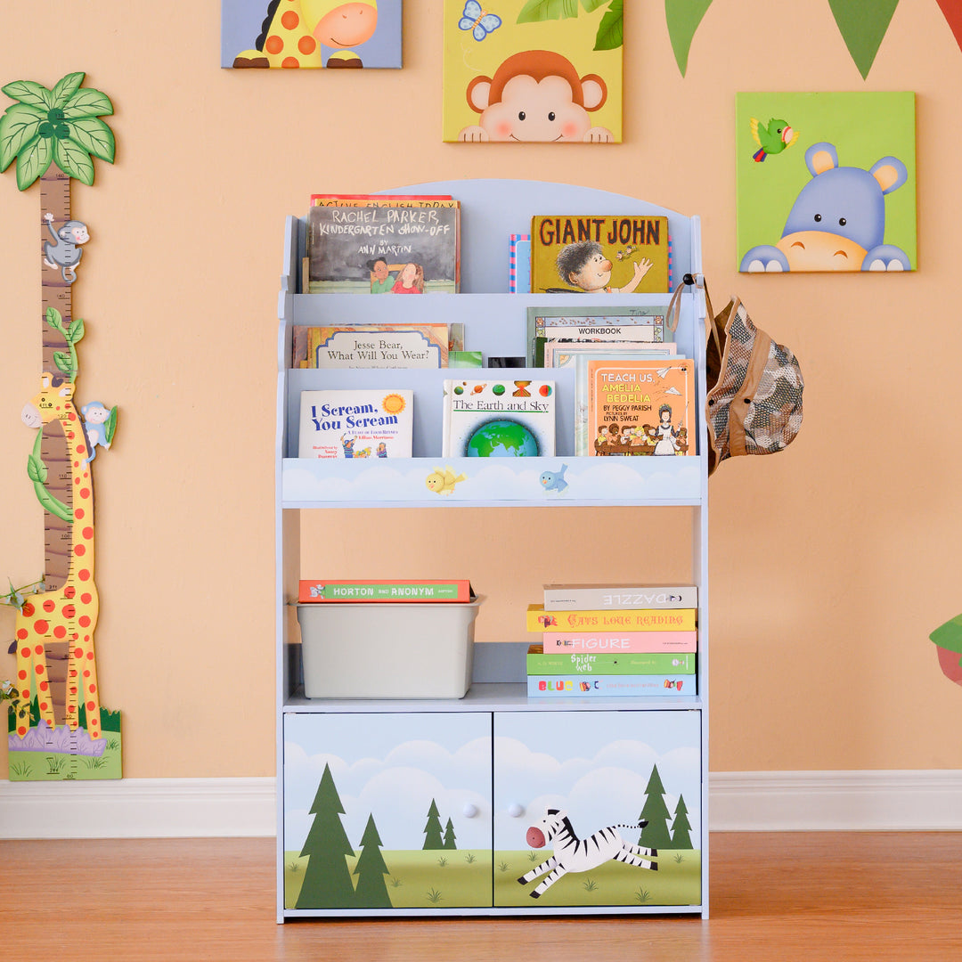 A Fantasy Fields Sunny Safari Kids 3-Tier Wooden Bookshelf with Storage, Multicolor with jungle creatures on it.