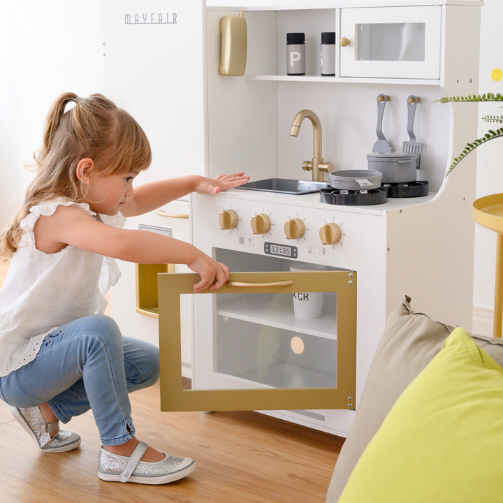 Little girl playing with the oven on the Teamson Kids Little Chef Mayfair Classic Kids Kitchen Playset.