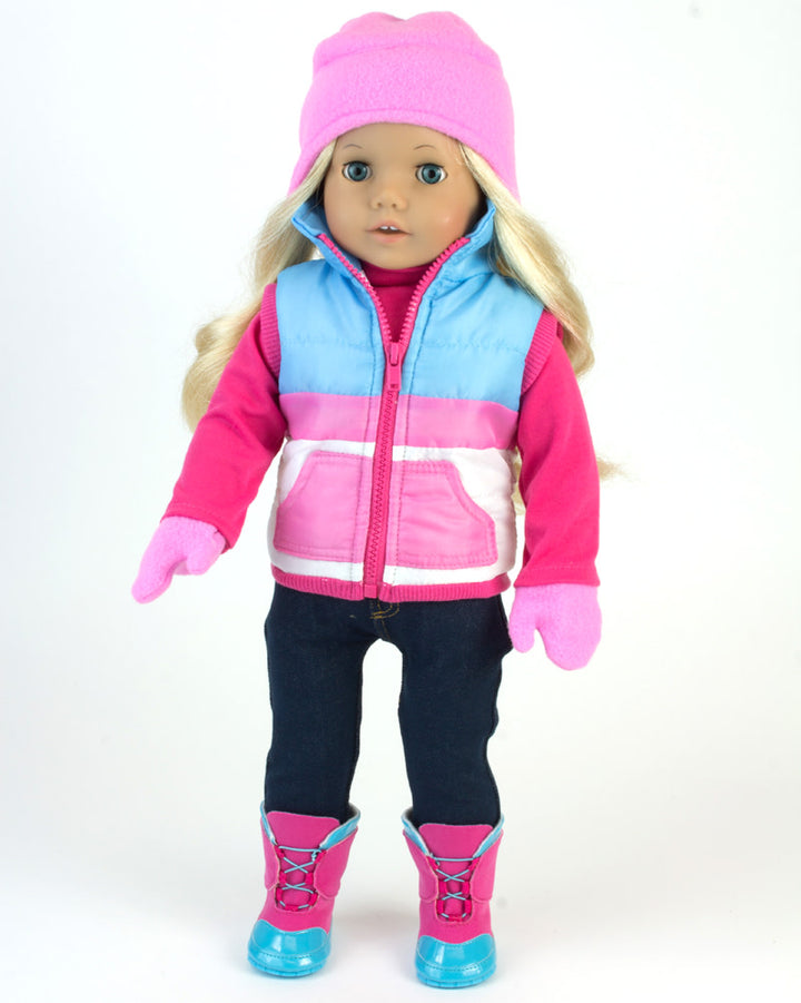 A blonde 18" doll with blue eyes dressed in a pink hat and gloves, blue and pink ski vest, blue and pink snow boots, and navy leggings.