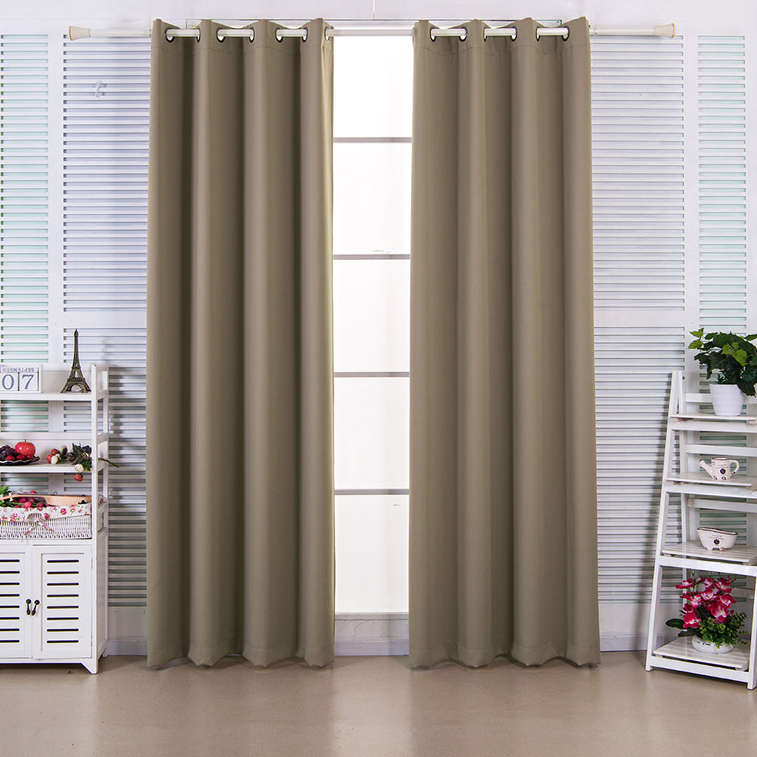 Khaki polyester curtains hung on a rod in a windowed room with white blinds and decorative Teamson Home 96" Ephesus Insulated Thermal Blackout Grommet Window Panels with Grommets, Sepia Brown shelves on either side.