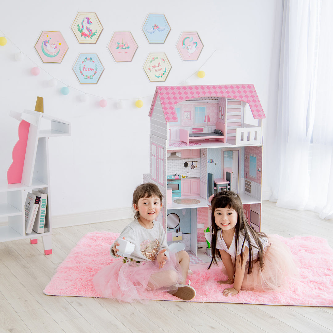 Two children playing with a Teamson Kids Ariel 2-in-1 Double-Sided Play Kitchen and its accessories in a brightly decorated room.