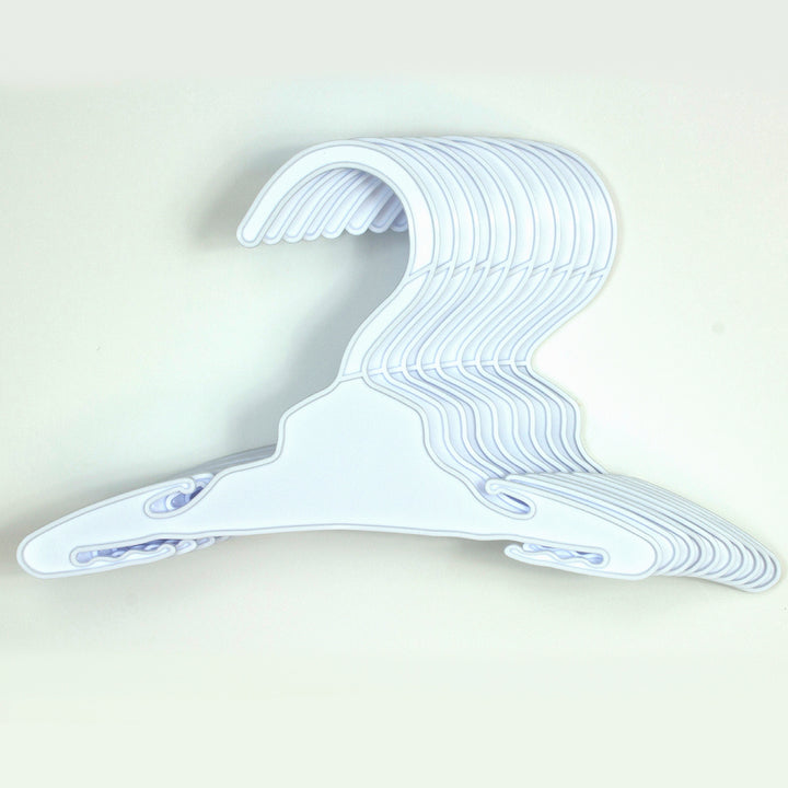 A set of Sophia’s 7 1/2" Plastic Hangers on a white wall, perfect for organization of 18" dolls.