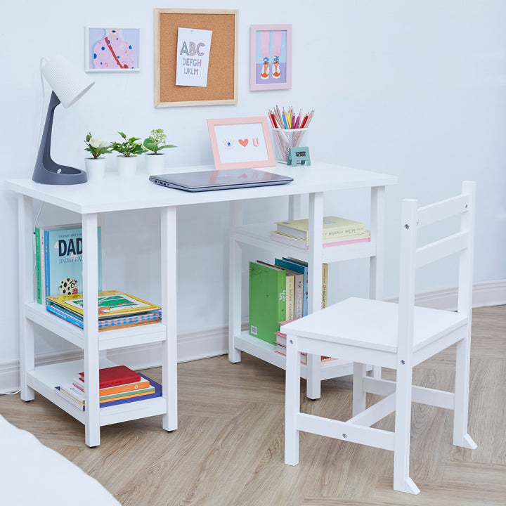 A white children's desk and chair with books on the shelves and a laptop and supplies on the desk.