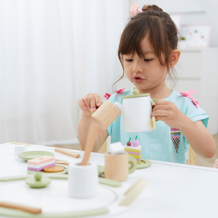 Teamson Kids - Little Chef Frankfurt Wooden Tea sets play kitchen accessories are on a table where a girl plays