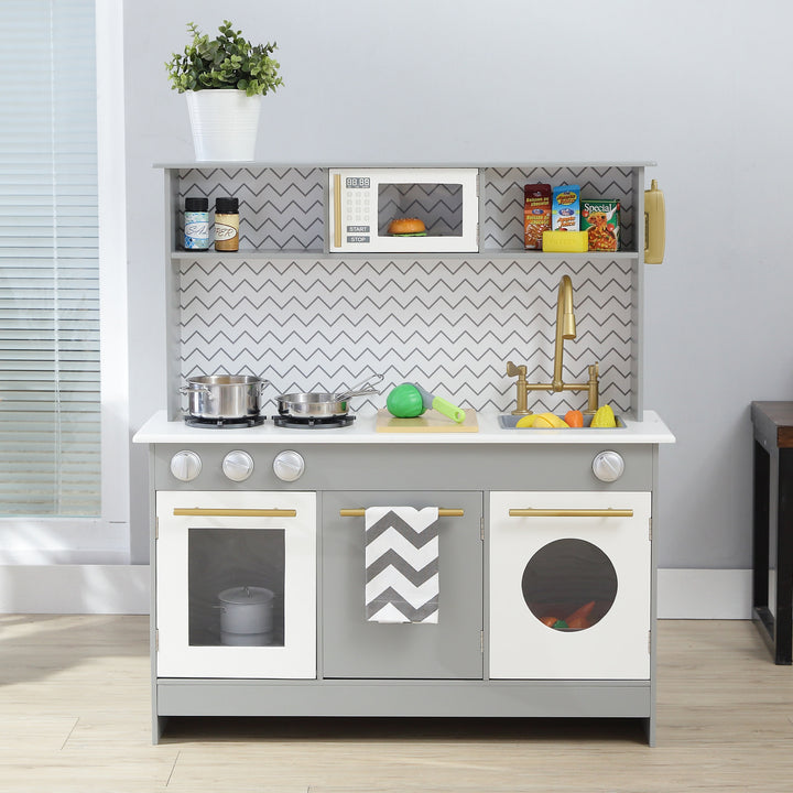 A Teamson Kids Little Chef Berlin Modern Play Kitchen with 6 Accessories, Gray/White with interactive features and a chevron backsplash, equipped with toy cookware, food, and utensils.