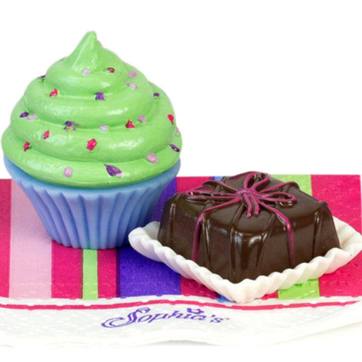 A green iced cupcake with sprinkles and a petit four with delicate pink icing.