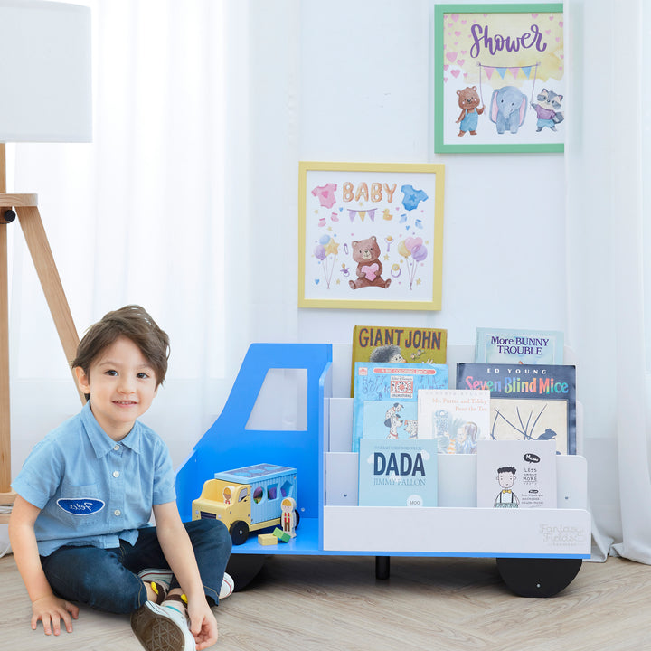 A little boy sitting next to the Fantasy Fields  Truck Wooden Display Bookcase, White/Blue