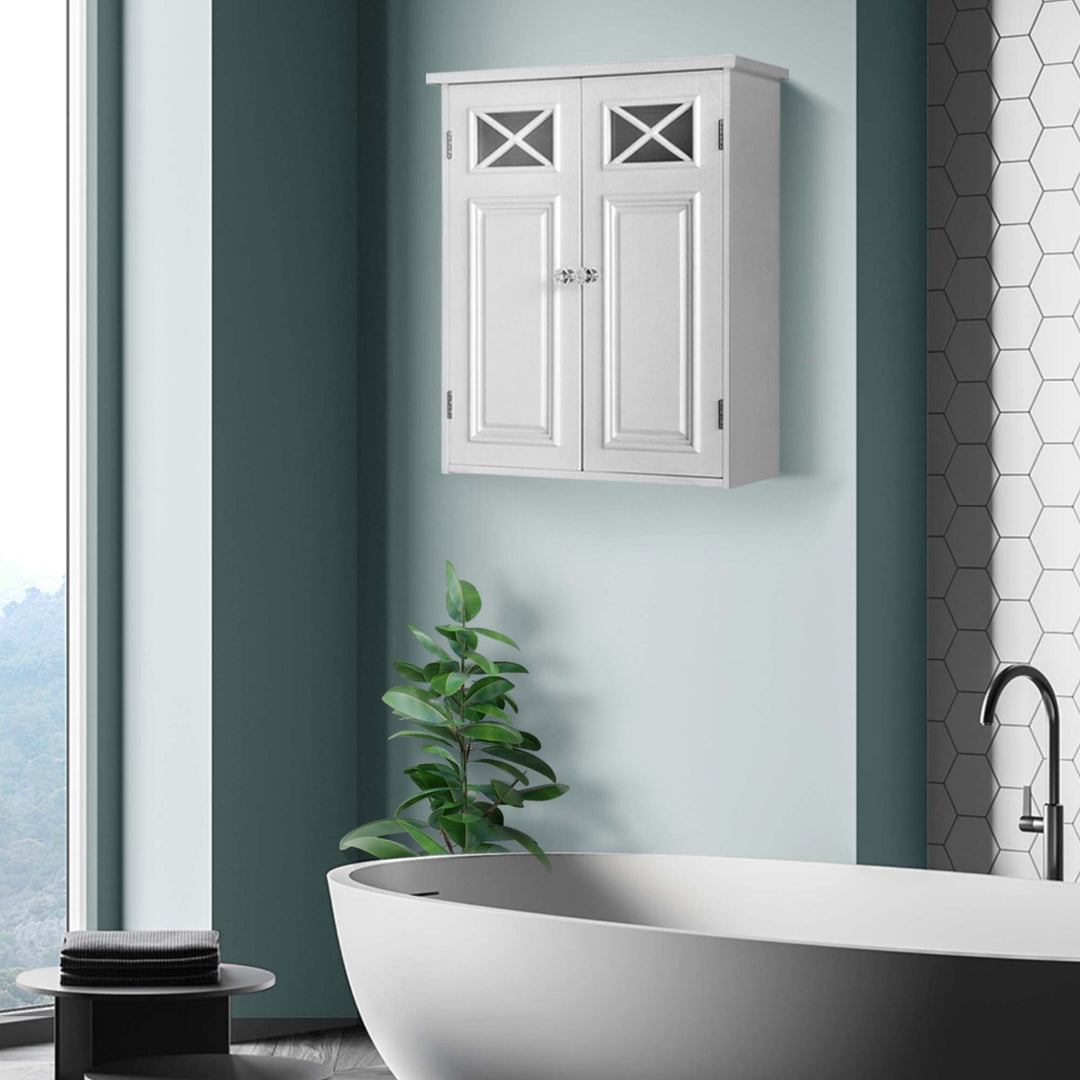 Elegant Home Fashions Dawson Removable Wooden Wall Cabinet with Cross Molding and 2 Doors - White above a freestanding bathtub, next to a green potted plant, with a hexagonal tile backsplash and a view of nature through a window