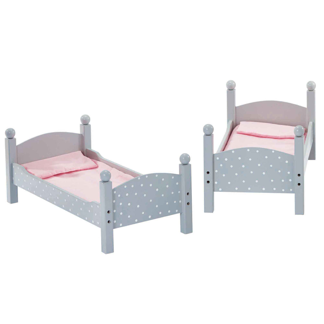 A gray with white polka dots bunk bed separated into two single beds with pink bedding, pink ladder.