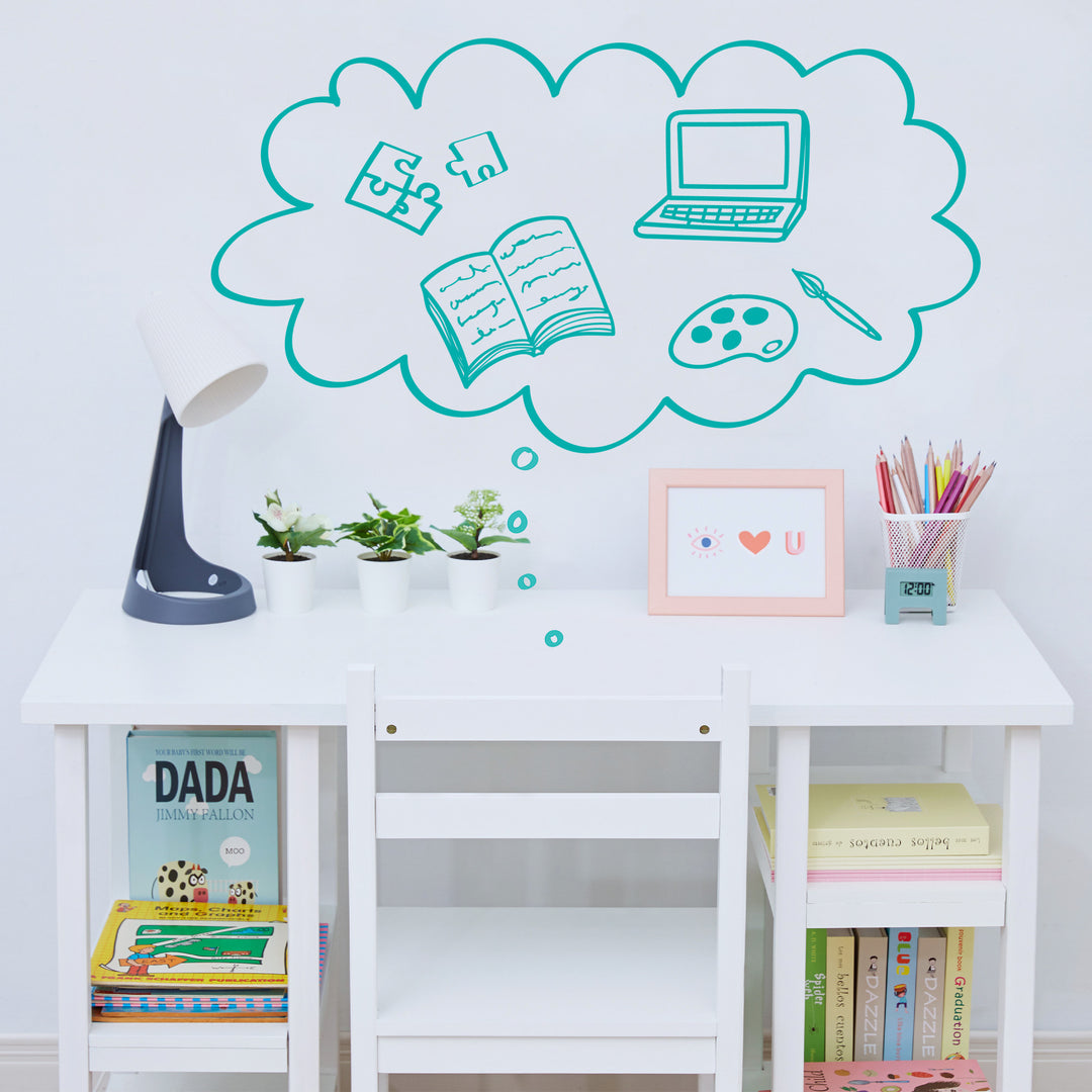 A white children's desk with a graphic of a puzzle, laptop, book, paint brush and pallette above a desk top.