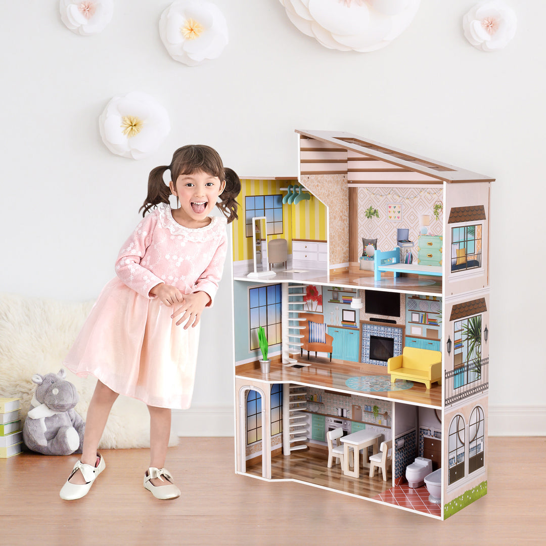 A little girl in a pink dress standing next to the three-story dollhouse.