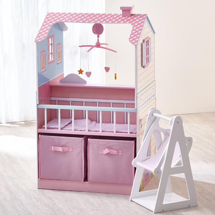 A baby doll changing station/dollhouse combination play set with a view of the crib, two storage cubes, and a separate baby doll swing.