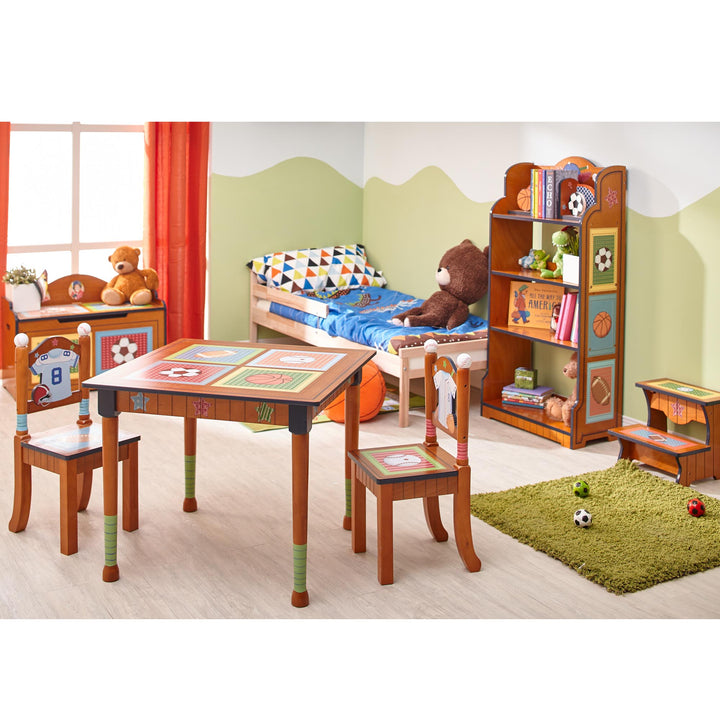 A children's room with a wooden table, chairs, and a Fantasy Fields Little Sports Fan Kids Furniture Tall Bookshelf, Brown.