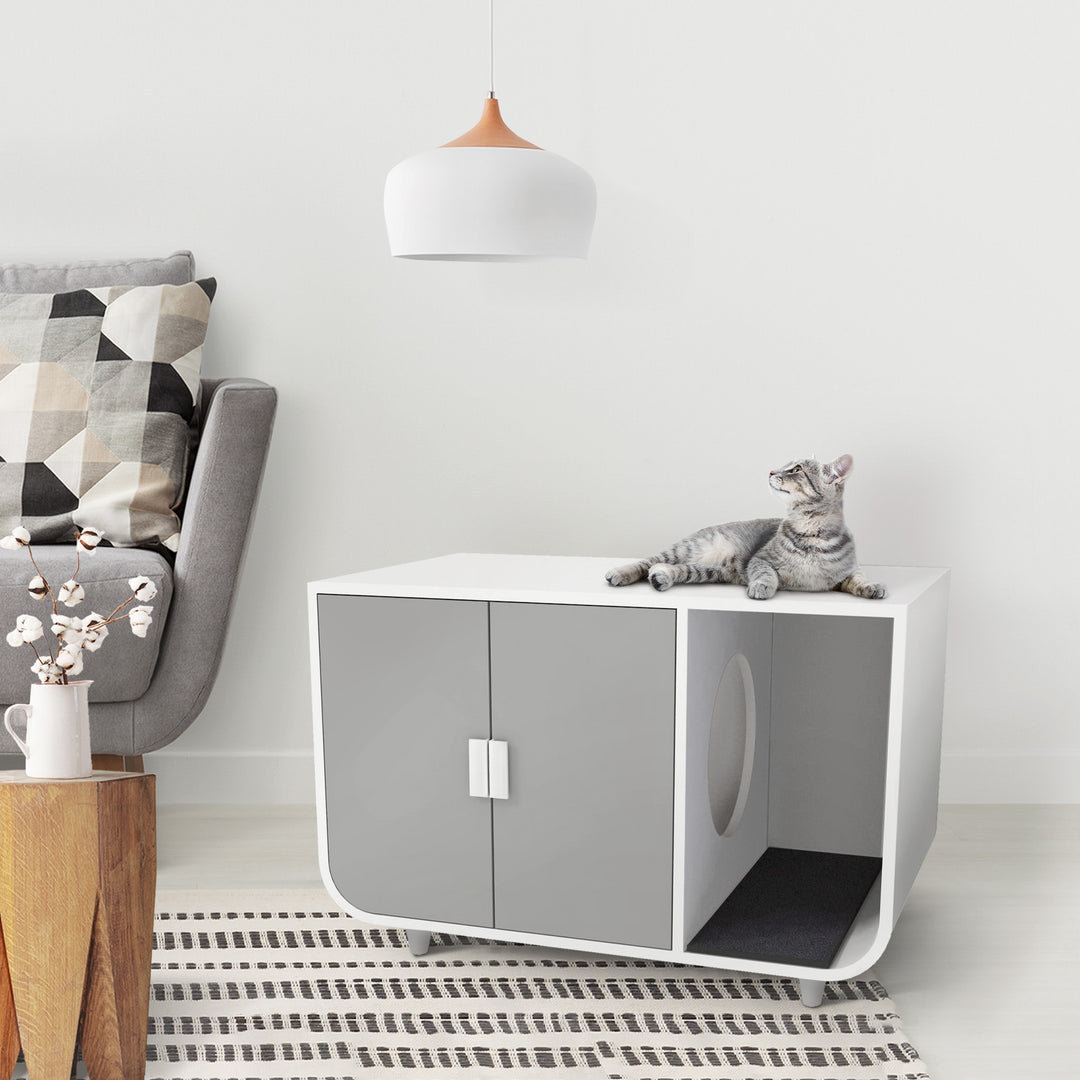 A tabby cat lounging on top of a Teamson Pets Large Dyad Wooden Cat Litter Box Enclosure and Side Table in a minimalist living room.