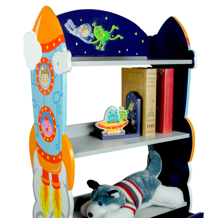 A Fantasy Fields Kids Wooden Outer Space Bookshelf with Drawer, Blue with a stuffed dog on it.