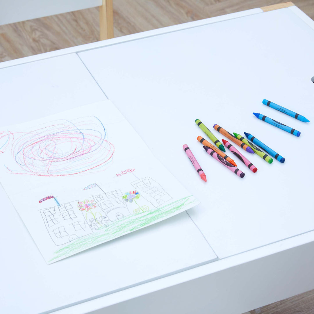 A picture drawn by crayons on top of a white child-sized table.