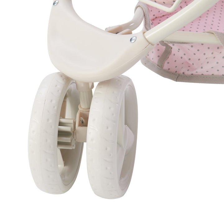 A close-up of the white all-terrain wheels at the front of the baby doll convertible stroller.