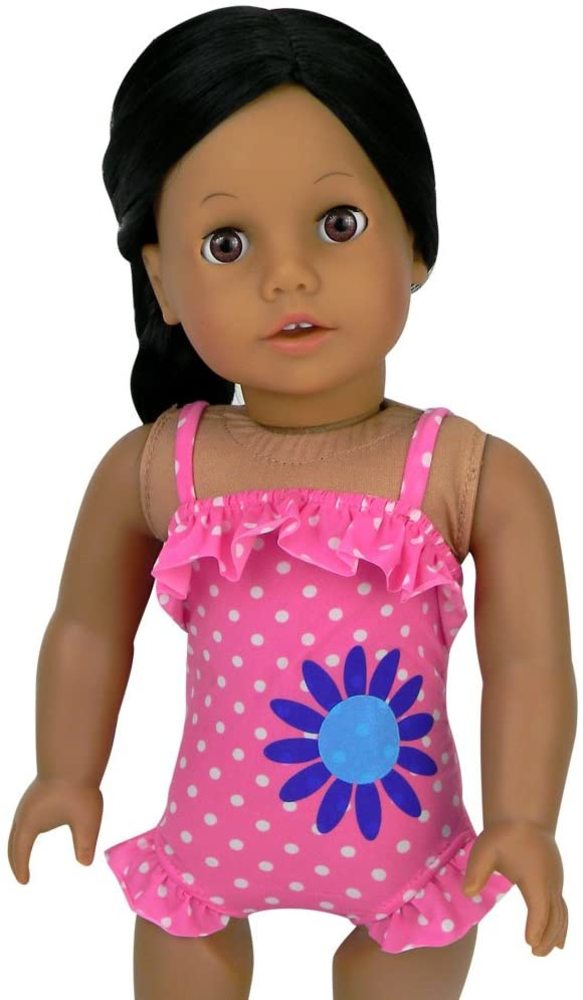 An 18" doll with brunette hair and brown eyes is wearing a pink ruffled polka dot bathing suit.