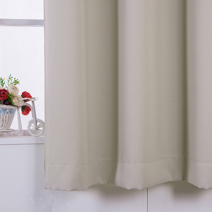 63" Tripoli Premium Solid Insulated Thermal Blackout Grommet Window Panels, Oyster curtains partially drawn with a bouquet of flowers on a windowsill in the background.