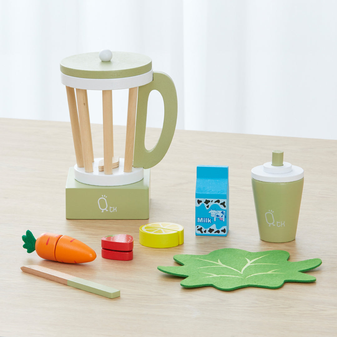 A Teamson Kids Little Chef Frankfurt wooden blender set with pretend ingredients and accessories on a tabletop.