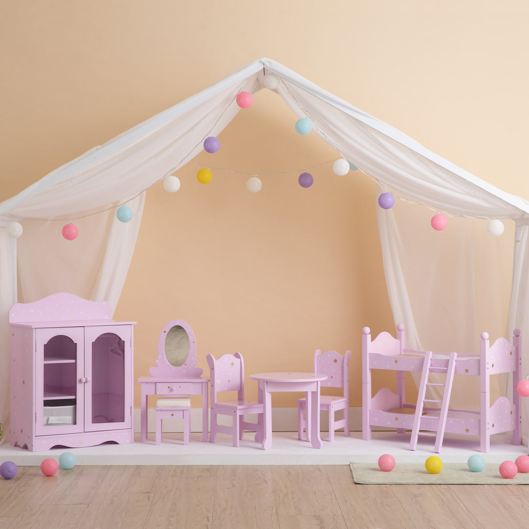 A white tent with colorful bunting with a set of pink 18" doll furnishings with white and gold stars: chiffarobe, vanity with stool, table with two chairs, and bunk bed with ladder.