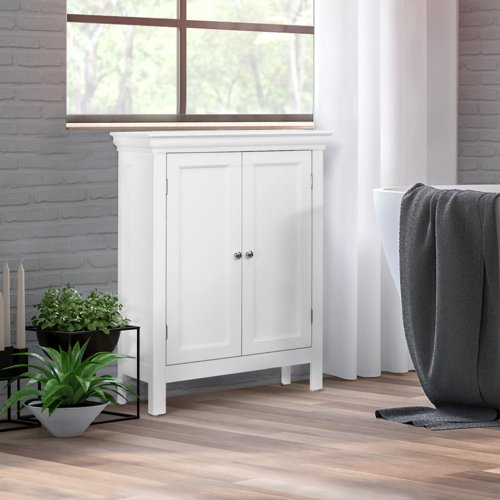 A White Teamson Home Stratford Floor Cabinet with chrome knobs underneath a window against a gray brick wall