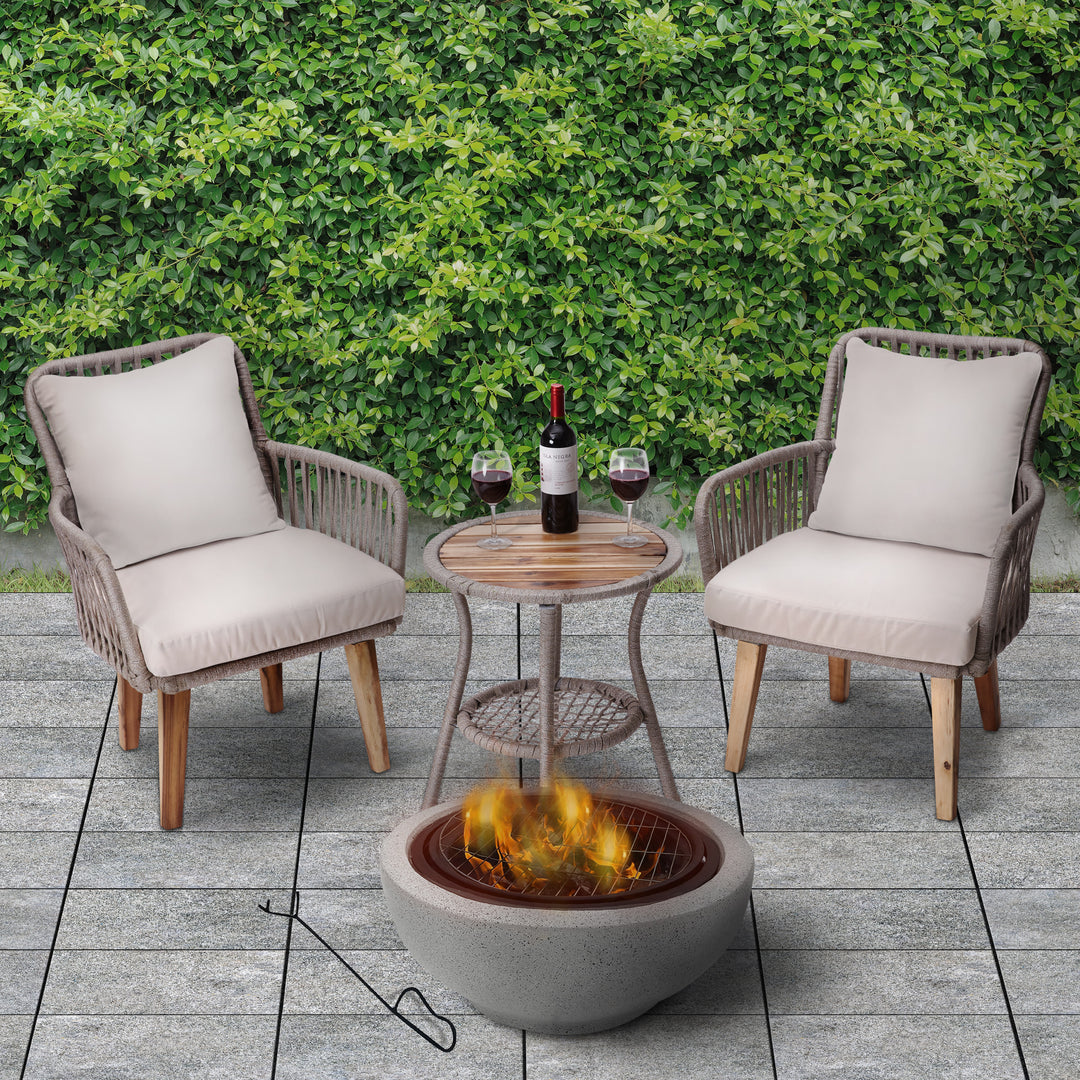A Teamson Home Outdoor 24" Wood Burning Fire Pit with Grill Grate and Faux Concrete Base, Gray on a slate deck next to an outdoor seating area