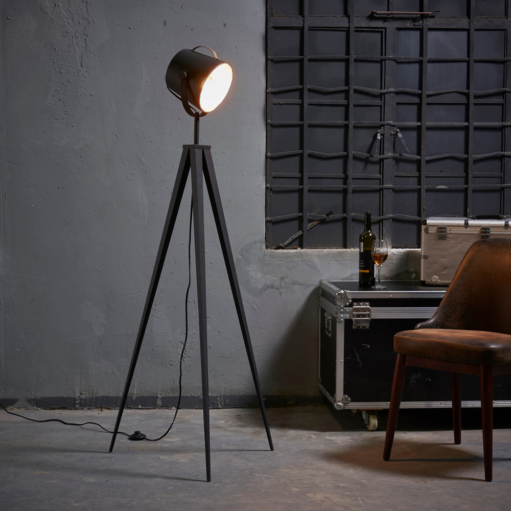 Teamson Home Artiste 62" Modern Spotlight Tripod Floor Lamp, Black with Gold Interior in an industrial-style room with a leather chair 