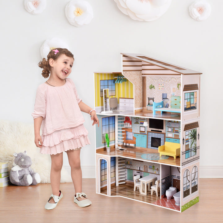 A little girl in a blush dress standing next to a three-story mid-century modern dollhouse in a playroom.