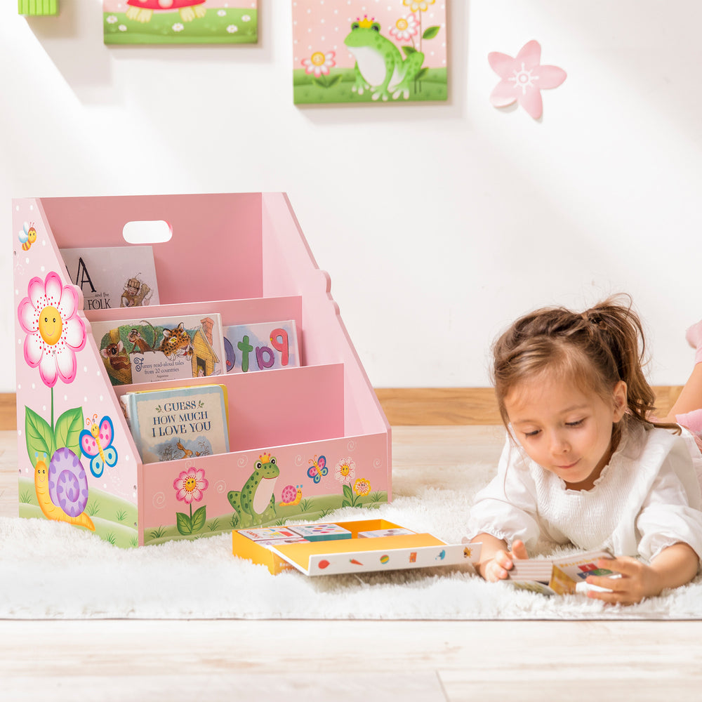 A girl playing on the Fantasy Fields Kids Painted Wooden Magic Garden 3-Tiered Bookshelf, Pink in the playroom.