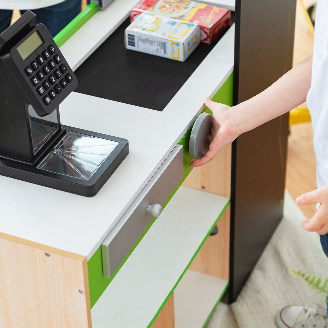 image shows a child turning a knob to move the conveyor belt down the register