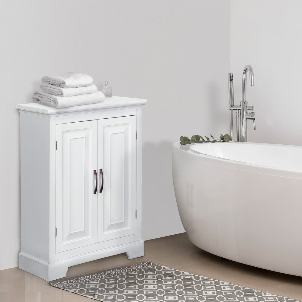 White Teamson Home St. James Two-Door Floor Cabinet with raised door panels next to a freestanding bathtub with towels on top.
