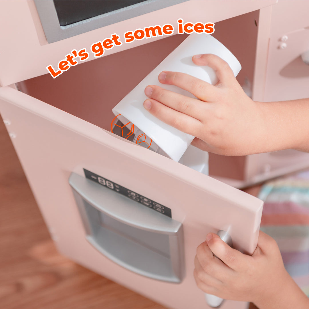 Child opening a toy microwave from their Teamson Kids Little Chef Westchester Retro Play Kitchen, Pink with the phrase "let's get some ices" on the display screen.