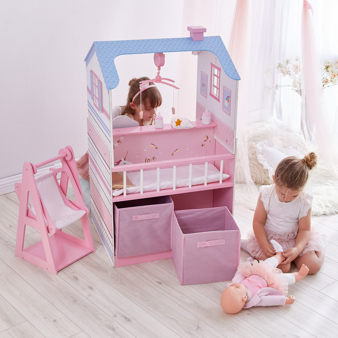 Two little girls playing on opposite sides of the baby doll changing station.