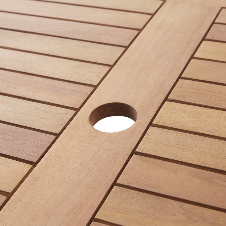 Close-up of the Acadia wood table top with the central hole for a patio umbrella (sold separately)