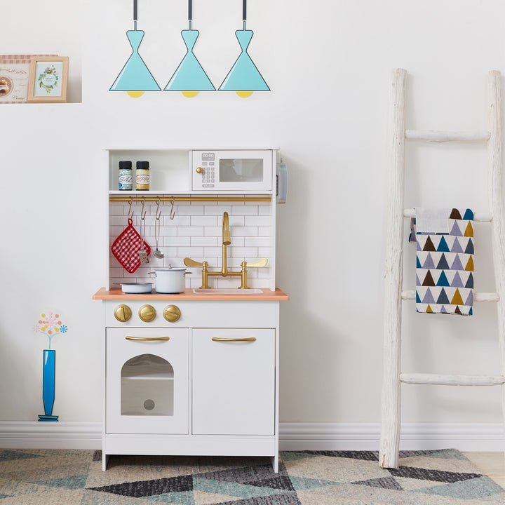 A Teamson Kids Little Chef Boston Classic Play Kitchen & Cookware, White with accessories in a room with decorative elements.