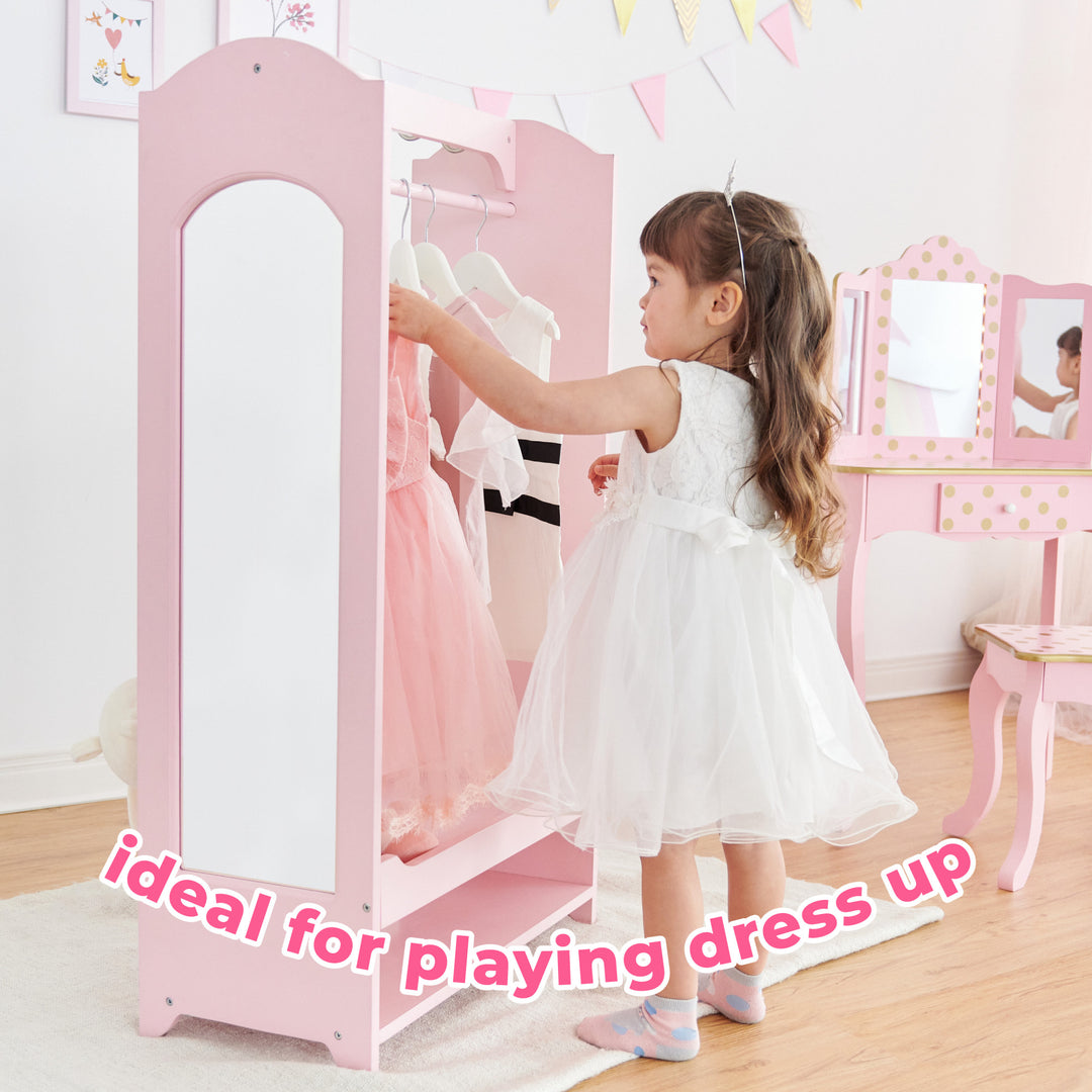 A little girl in a white dress hanging up a pink dress on a pink wardrobe with the caption "ideal for playing dress up".