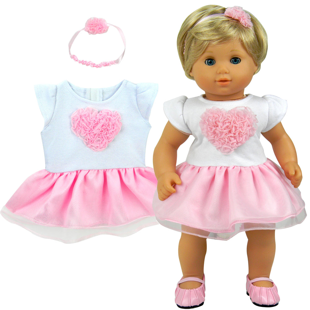 A blonde 15" baby doll with a white capped sleeved dress with a pink tulle heart and skirt and headband.