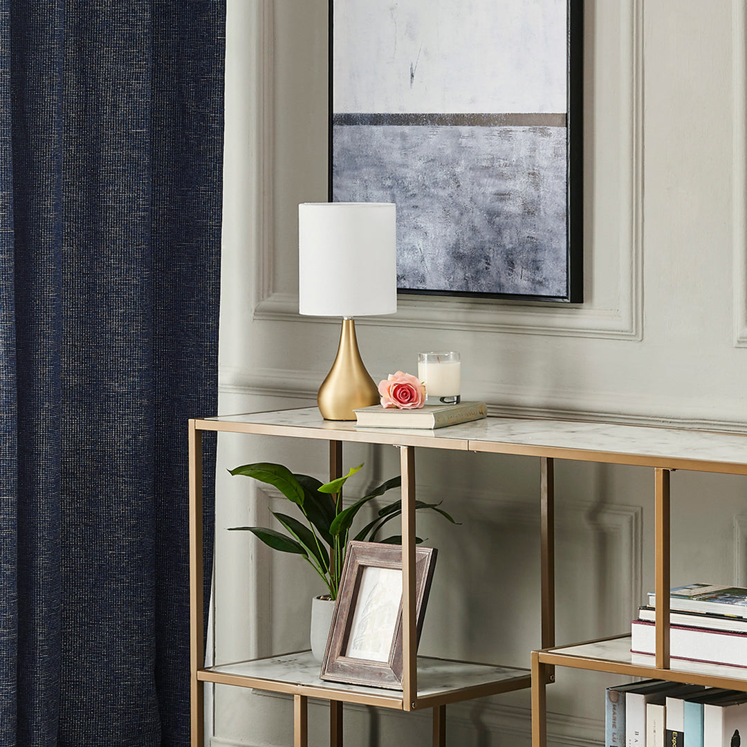 A living room with a brass console table and a Teamson Home Sarah 15" Modern Metal Table Lamp.