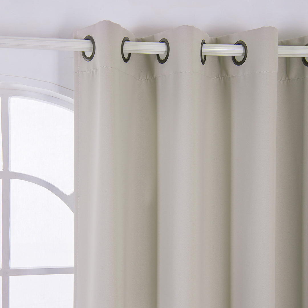 63" Tripoli Premium Solid Insulated Thermal Blackout Grommet Window Panels, Oyster curtains hanging on a metal rod in front of a window with white frames.