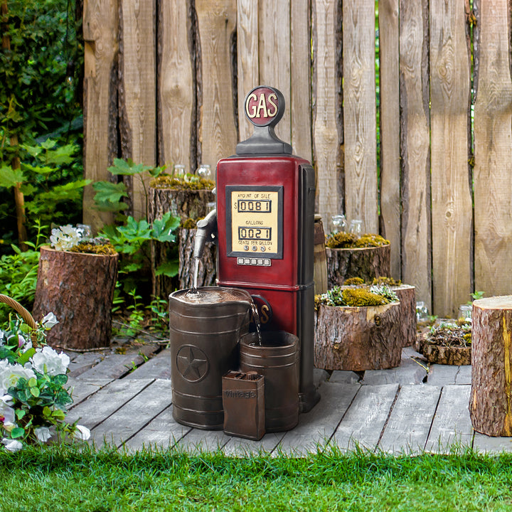Teamson Home Outdoor Vintage Gas Pump water fountain in a backyard setting with wooden stools and planters.