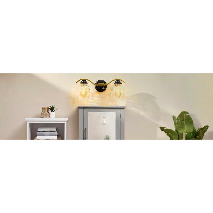 Teamson Home Heidi 2-Light Vanity Fixture with Clear Hammered Glass Cloche Shades, Black/Brass  above a bath vanity
